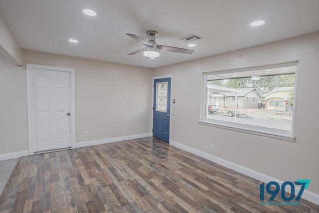 Living room with wood-look plank flooring and a blue front door