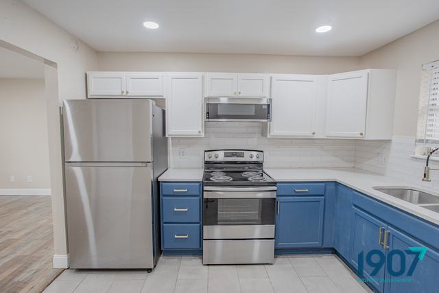Kitchen with stainless steel range, microwave, and refrigerator
