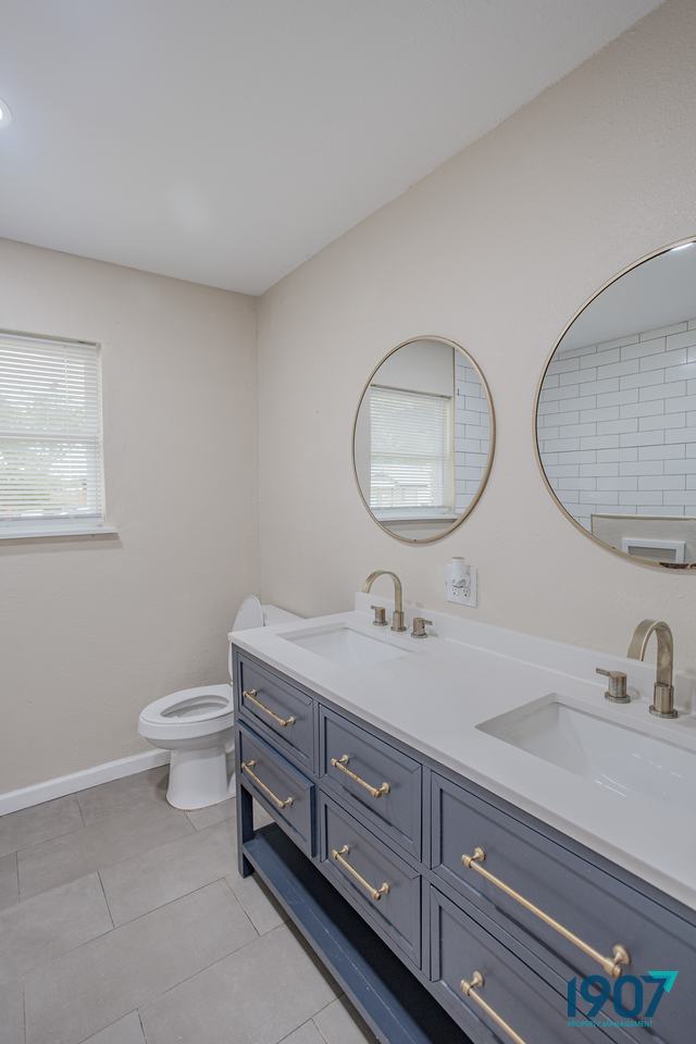 Double vanity with a blue cabinet and round mirrors