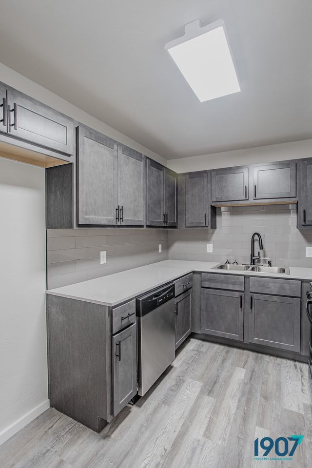 Kitchen with gray cabinets and white countertops