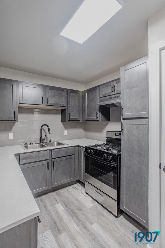 Kitchen with gray cabinets and a stainless steel range