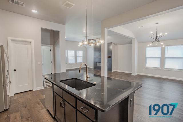 Kitchen island with dark cabinets and a stone countertop