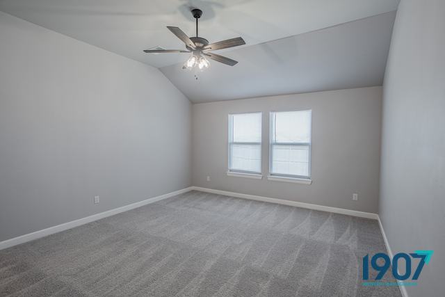 Bedroom with a vaulted ceiling and carpet