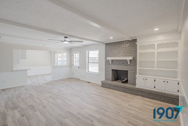 Living room with a painted brick fireplace and built-in shelving