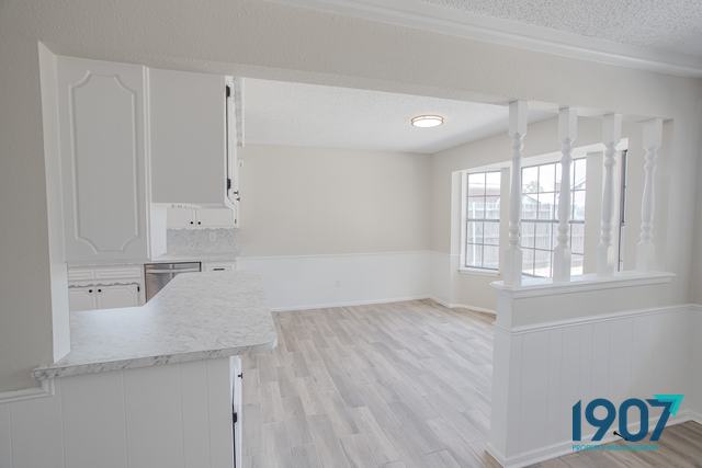 Kitchen with white cabinets opening onto the dining area