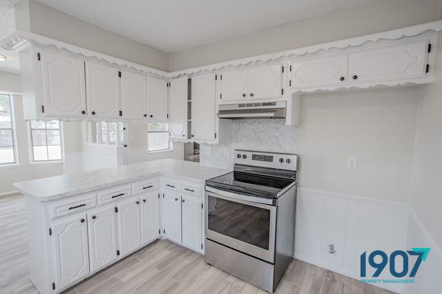 Kitchen with white cabinets and a stainless steel range